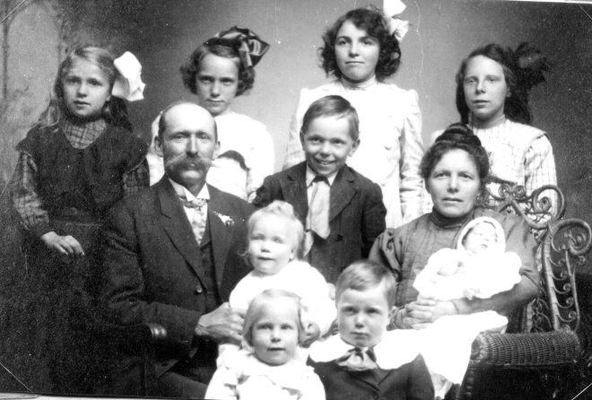 Back row: Bertha, Anna, Clara, Louise. Seated row: Charles, Charles, Christina. Lap children: Preston, Laura. Front: Ida, Joseph.